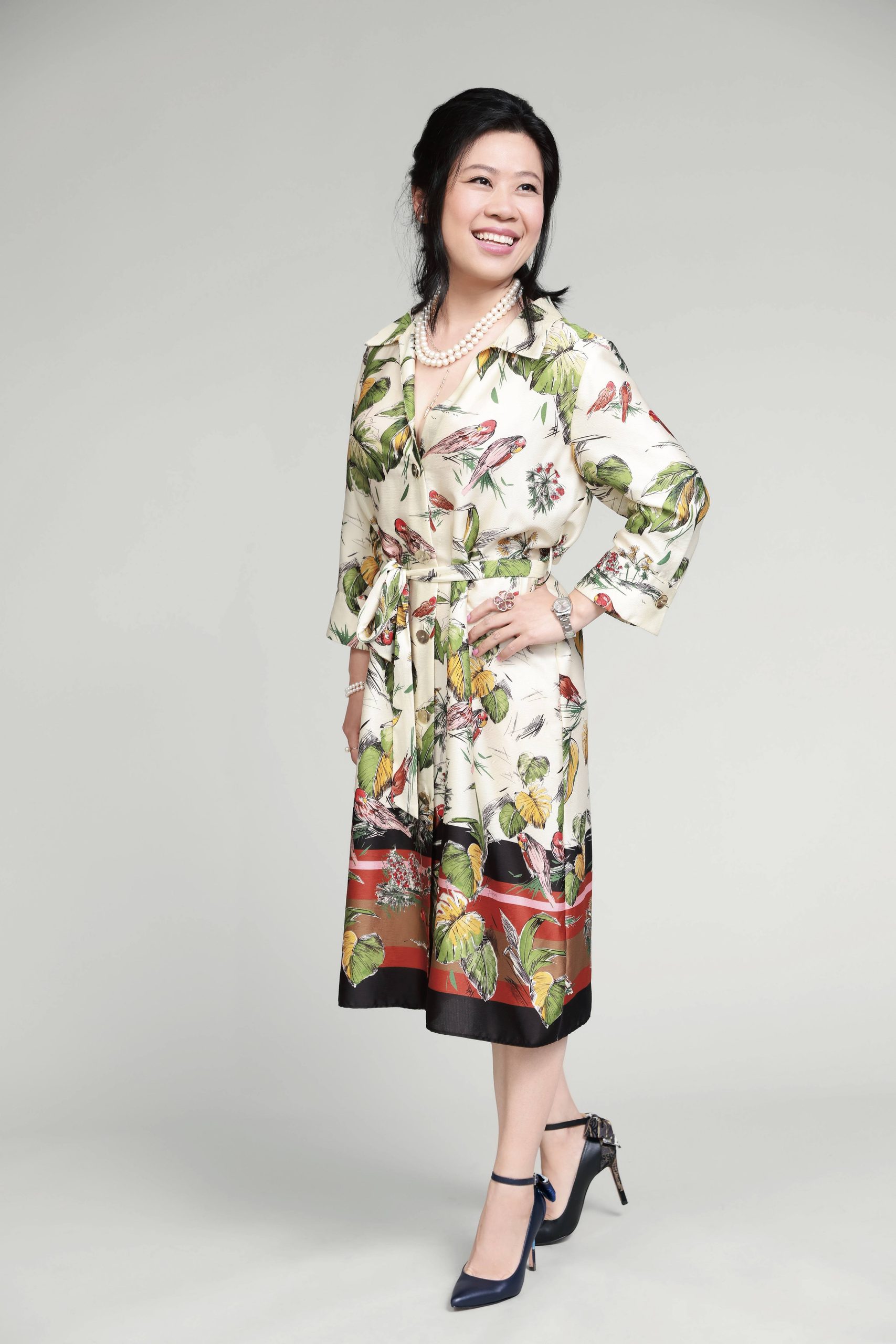 Woman in floral dress, smiling confidently.
